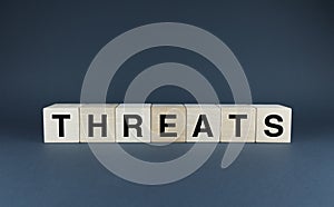 Threats. Cubes form the word Threats