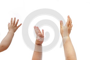 Three 1 year old babies raise hands to show their wish isolated on white