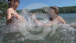 Three active boys making splashes in water.