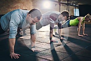 Three adults performing push up exercises