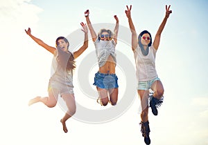 Three agile energetic teenagers leaping in the air