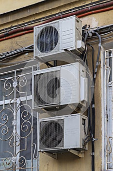Three air conditioners on the facade of an old house