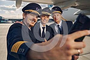 Three airmen in uniforms taking selfies at the airport