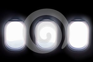 Three airplane windows open white window shutter wide