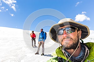 Three alpinists friends walking climbing ice glacier mountain An