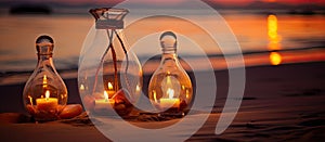 Three amber candles in glass bottles on a beach at sunset