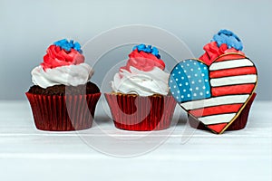 Three American patriotic themed cupcakes for the 4th of July with heart shaped american flag. Shallow depth of field.