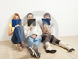 Three amused friends with books