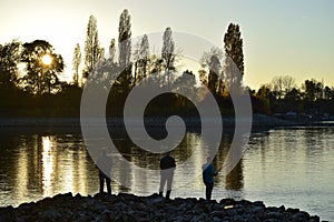 Three anglers by the river Rhine