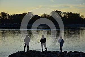 Three anglers by the river Rhine