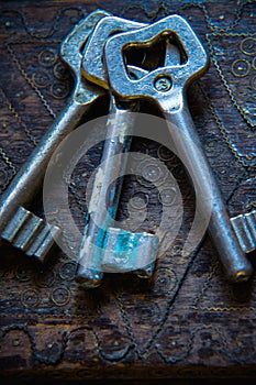 Three antique keys on wooden table