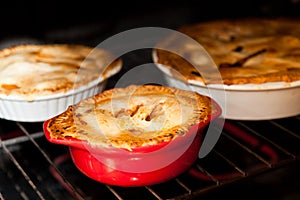 Three apple pies cooking