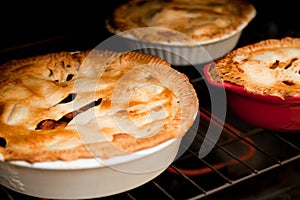 Three apple pies cooking in the oven