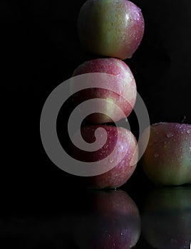 Three apples with drops of water. on a black background.