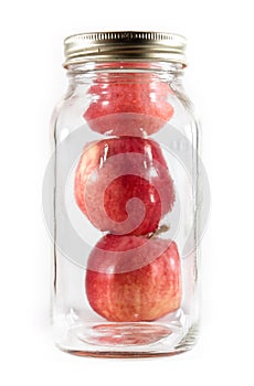 Three apples in a glass mason jar for canning