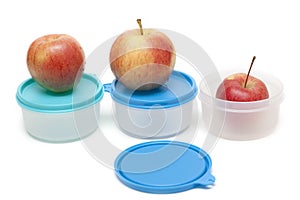 Three apples and plastic containers