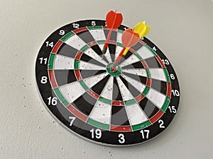 Three arrows stuck in a black, white, green and red arrow board photo
