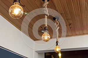 Three artesanal yellow light bulbes with wooden roof and blue & white paiting photo