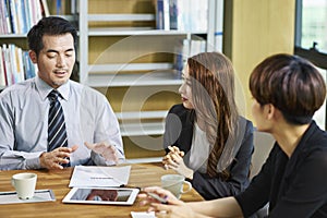 Three asian businesspeople meeting discussing business in office