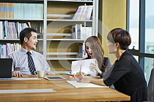 Three asian businesspeople meeting discussing business in office