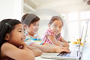 Three Asian Children Using Laptop At Home