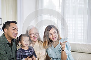 Three Asian generation family watching TV at home