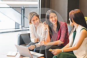 Three Asian girls chatting on sofa at cafe or coffee shop together. Gossip talks, Casual lifestyle with gadget technology concept