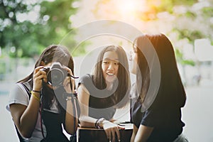 Three asian teenager  with dslr camera in hand pose as fashion model