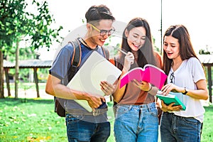 Three Asian young campus students enjoy tutoring and reading books together. Friendship and Education concept. Campus school and