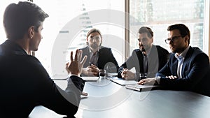 Three attentive hr manager listening to job candidate at meeting