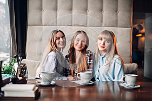 Three attractive girlfriends having lunch in cafe
