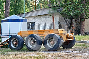 Three axle orange circus hindcarriage trailer for transporting goods in park