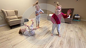 Three baby girls triplets sister are dancing at home in the room, pajamas are dressed