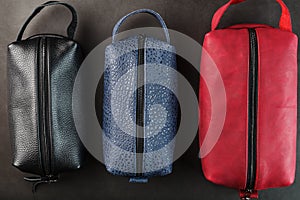 Three bags, black, blue and red with genuine leather locks on a black background