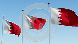 Three Bahrain flags on flagpole in front of blue sky