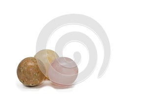 Three balls made of natural stone. Rose quartz, yellow calcide and jasper. Isolated on white, copy space