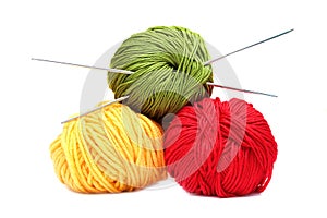 Three balls of wool with knitting needles