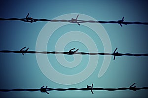 Three barbed wire lines and light blue background