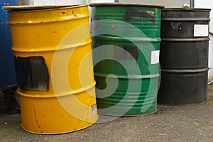 Three barrels in a row, yellow, green and black