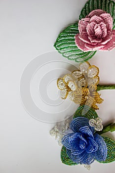 Three beaded flowers on a white background.