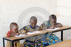 Three beautiful African Children in School Taking Notes during C
