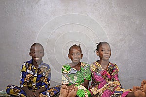 Three beautiful African Children Sitting and Smiling in Room with Copy Space