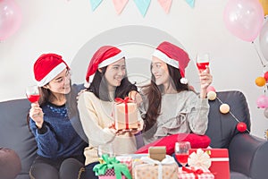 Three beautiful asian girls celebrating Christmas with wine