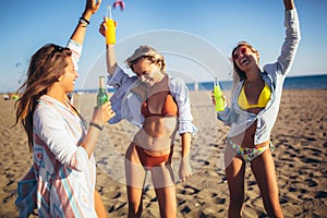 Three beautiful attractive young women having fun on the beach