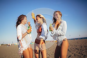 Three beautiful attractive young women having fun on the beach