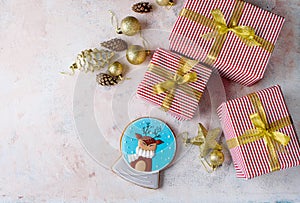 Three beautiful boxes with gifts in beautiful design and decor, gingerbread in the form of a New Year`s magic ball with a deer.