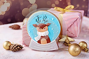 Three beautiful boxes with gifts in beautiful design and decor, gingerbread in the form of a New Year`s magic ball with a deer.