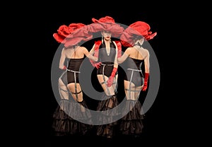 Three beautiful cabaret dancers in red hats isolated on black