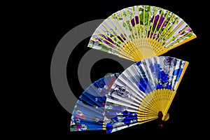 Three beautiful chinese folding paper fans against dark background