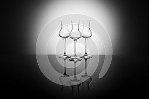 Three beautiful elegant glasses for grappa backlight, with reflection